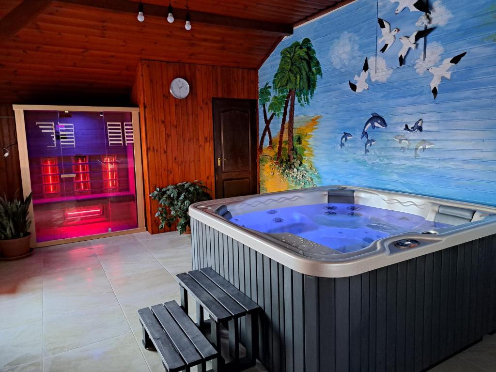 bañera de hidromasaje grande en una habitación con 2 bancos en Gólya-Tó Vendegház 2, en Vajdácska