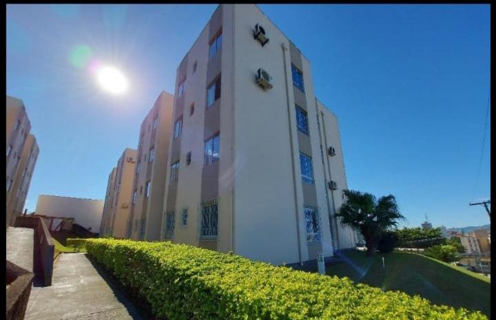 a building with a hedge in front of it at Apartamento bem localizado in São José