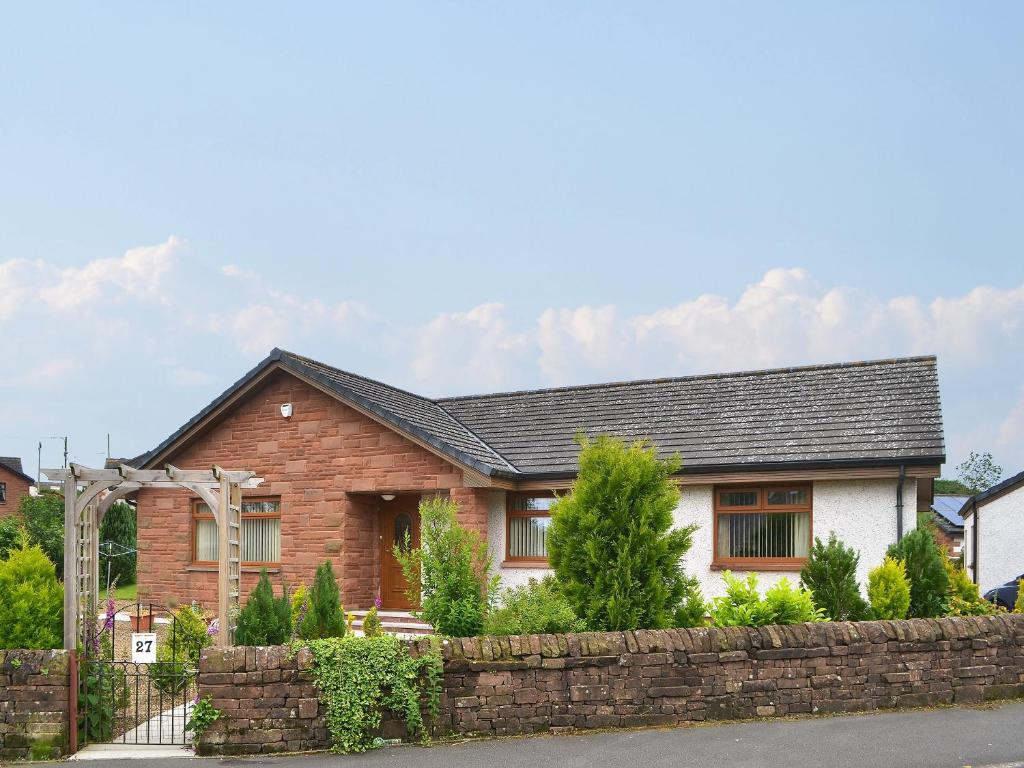 a house with a stone fence in front of it at Riverside in Annan