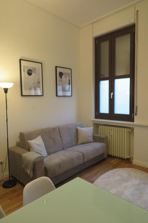 - un salon avec un canapé et une fenêtre dans l'établissement Incantevoli Appartamenti Navigli, à Milan