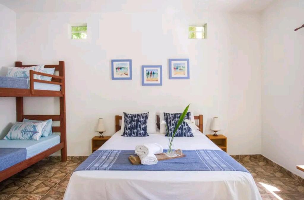 een slaapkamer met een bed en 2 stapelbedden bij Loft Praia Brava - Suíte com Área Gourmet Privativa in Ubatuba
