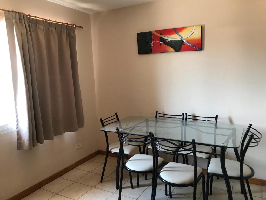 une salle à manger avec une table et des chaises en verre dans l'établissement Playa 497, à Pinamar