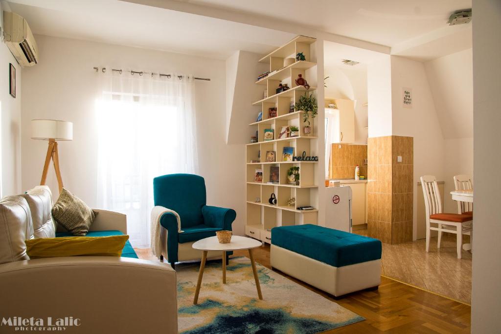 een woonkamer met een bank, stoelen en een tafel bij Sunny 412 apartment in Podgorica