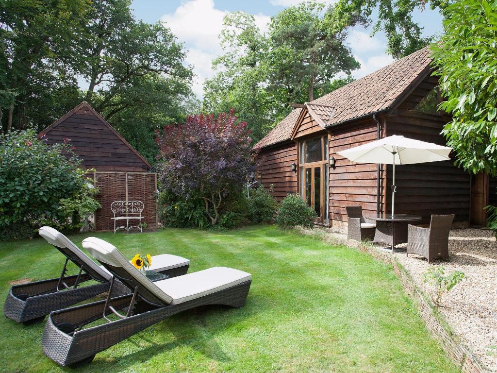 a backyard with a table and chairs and an umbrella at The Barn in Burley