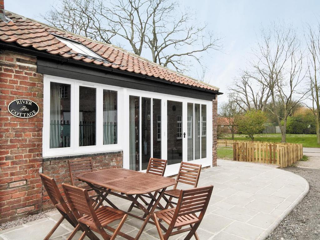 a patio with a table and chairs in front of a house at River Cottage - E5462 in Wainfleet All Saints