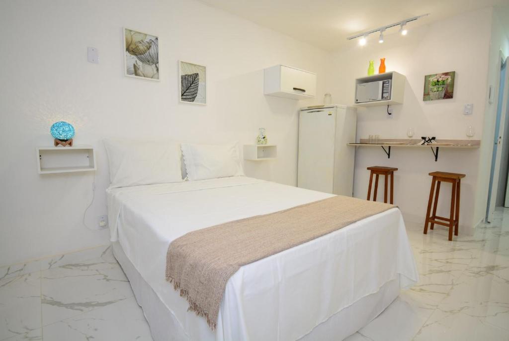 Habitación blanca con cama y nevera. en Petit Copa - Aconchego e praia!, en Río de Janeiro
