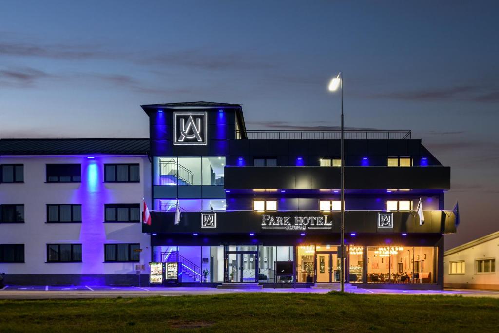 un bâtiment avec des lumières bleues devant lui dans l'établissement PARKHOTEL BRAUNAU - 24 Stunden Self Check-IN, à Braunau am Inn