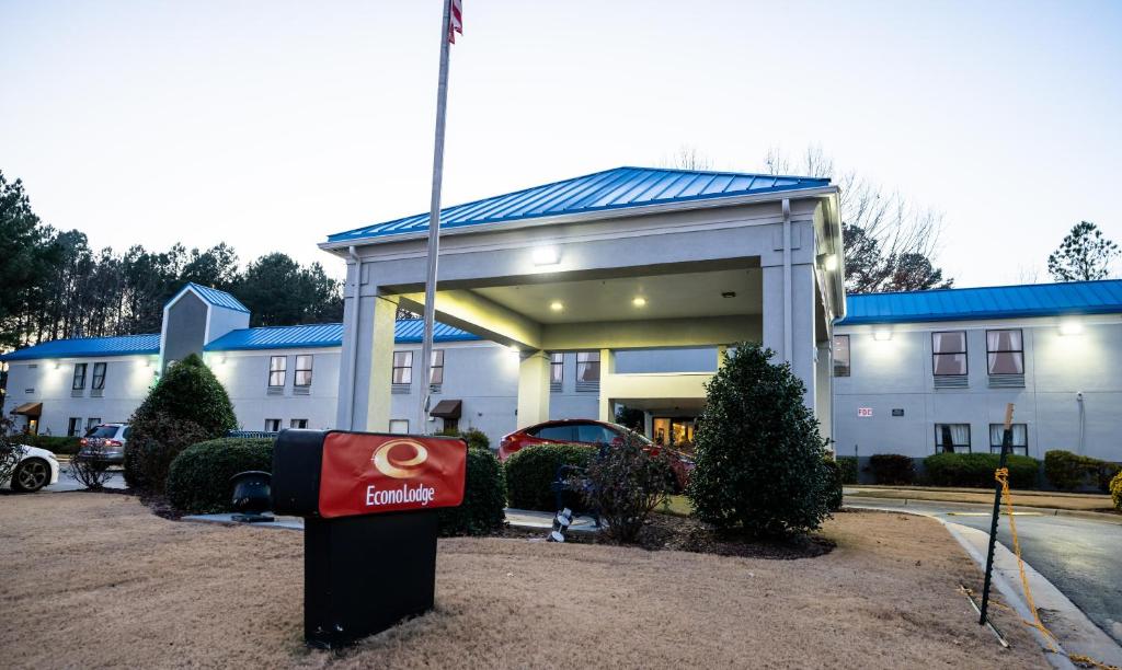 a large white building with a building with a sign in front at Econo Lodge in Raleigh