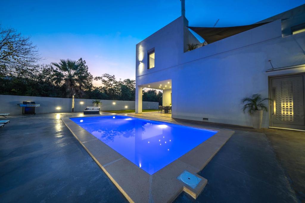 a swimming pool in the backyard of a house at La Maison Du Soleil Luxury Villa by 8essentially in Varípetron