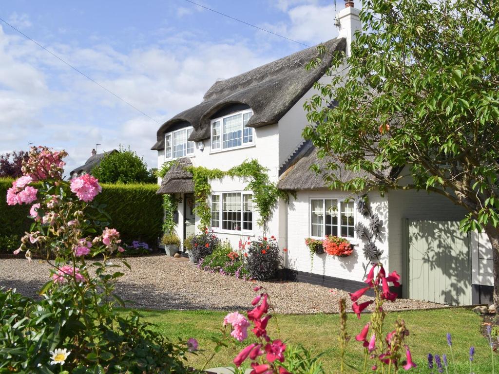 a white house with a thatched roof at Captains Cottage - 27888 in Winterton-on-Sea
