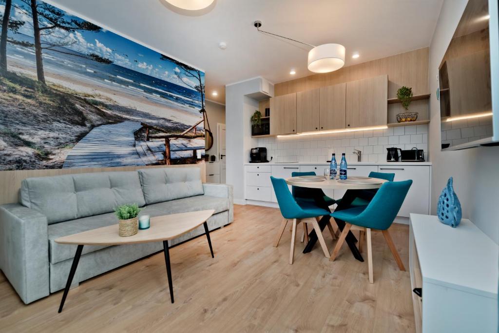 uma cozinha e sala de estar com um sofá e uma mesa em Apartament Zatoka 19 em Puck