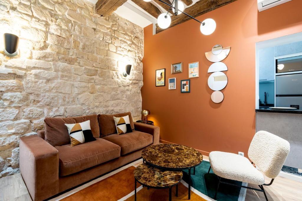 a living room with a couch and a stone wall at HolidaysInParis - Bonne Nouvelle in Paris