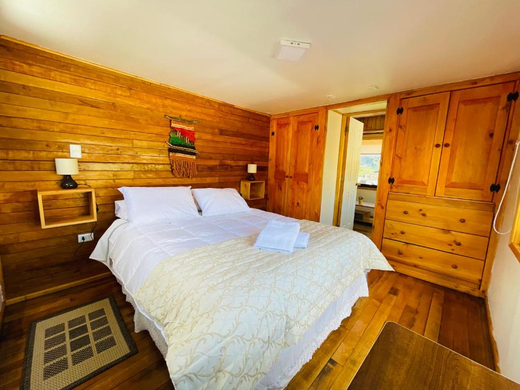 een slaapkamer met een groot bed en houten wanden bij Apartamento Coyhaique in Coihaique