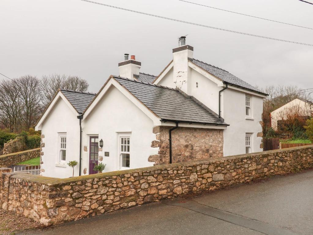 a white house with a stone wall at Castle House in Rhyl