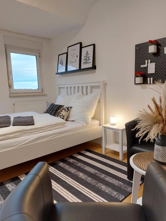 Un dormitorio con una gran cama blanca y una ventana en Rooftrop Apartments Ulm - komfortable neue Unterkunft im Herzen von Ulm en Ulm