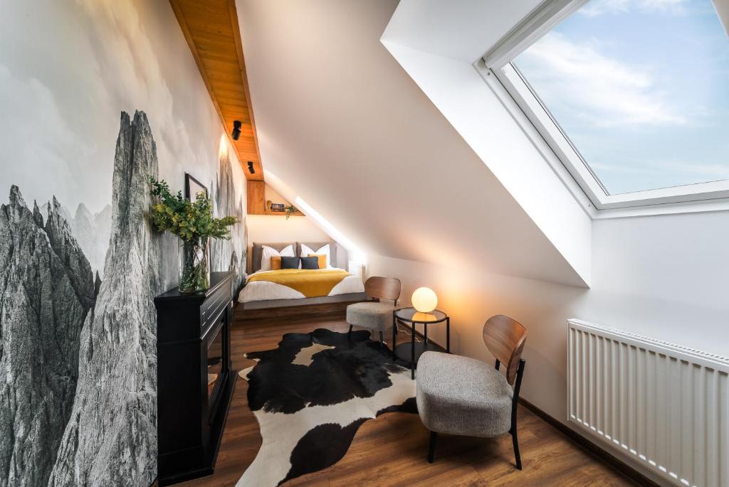 a attic bedroom with a skylight and a cow rug at Cozy mountain attic apartment in High Tatras in Veľká Lomnica