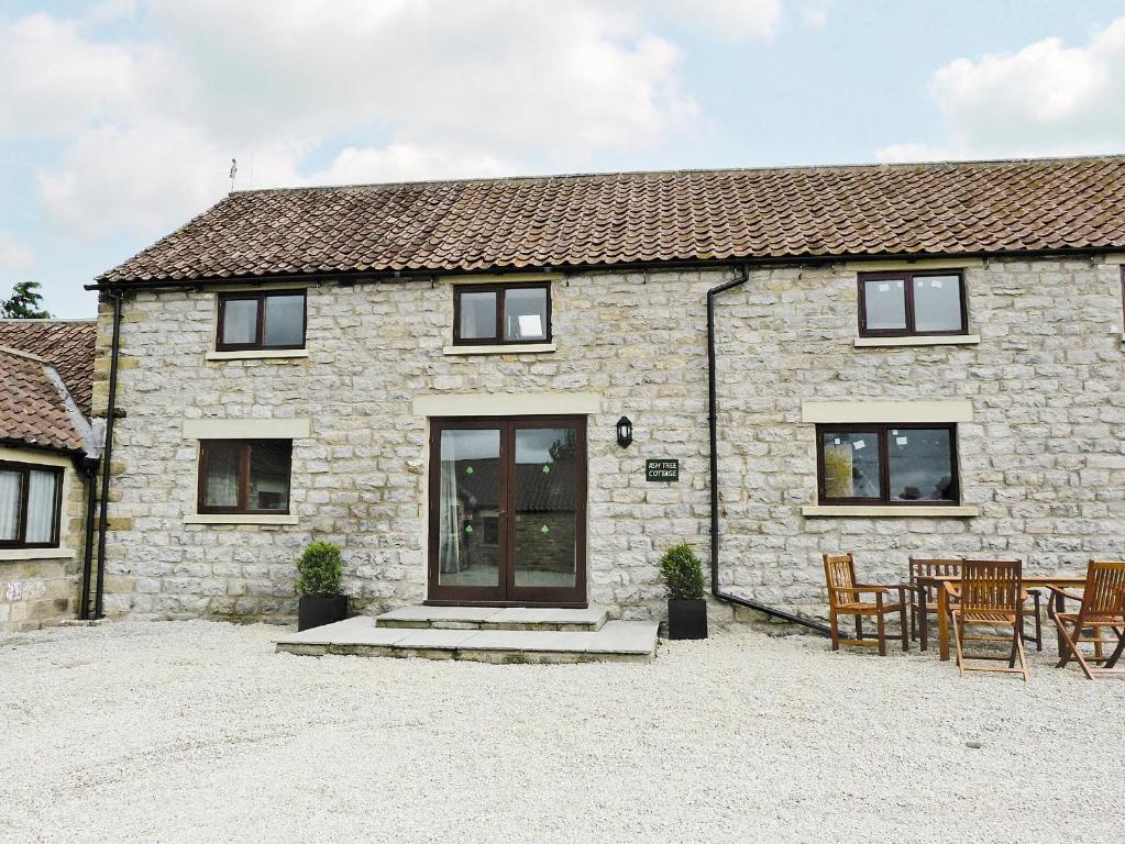 a stone cottage with a table and chairs in front of it at Ash Tree Cottage in Gillamoor