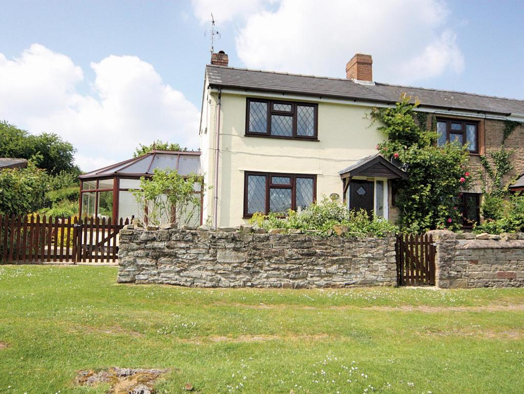 une maison avec un mur en pierre et une clôture dans l'établissement Oak Tree Cottage - E5062, à Lydbrook