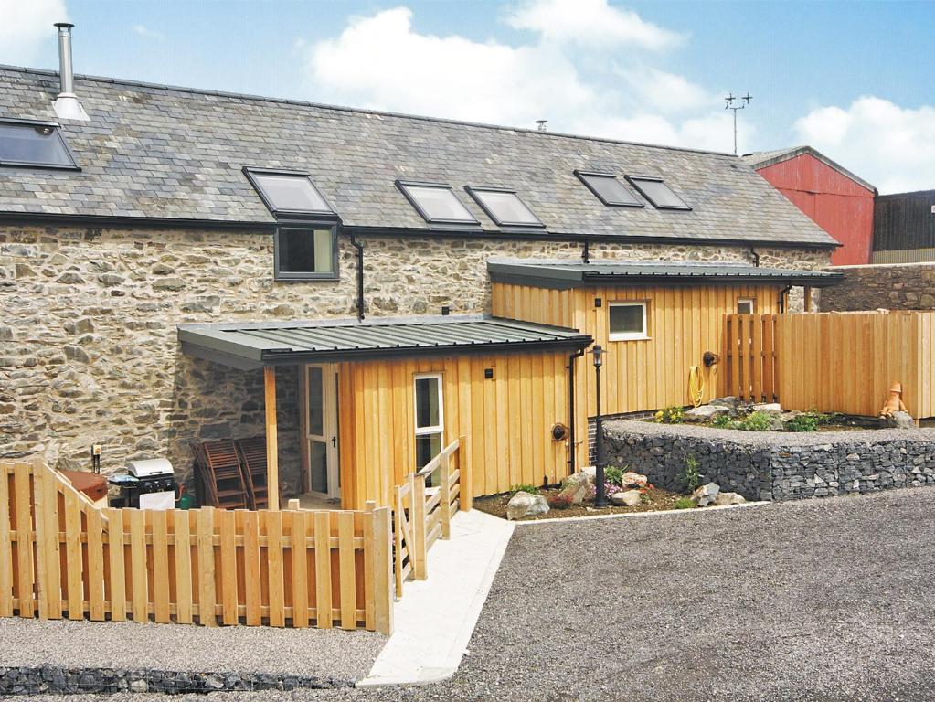 a house with a wooden fence in front of it at Stable Barn - Hw7591 in Bettws-yn-Rhôs
