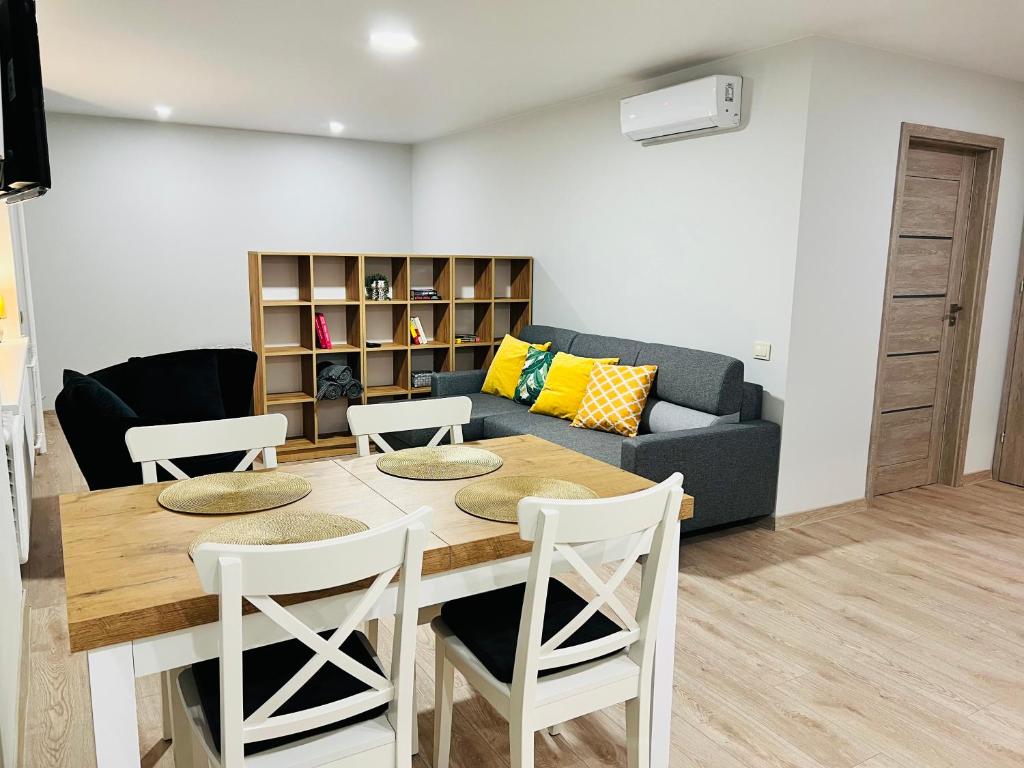 uma sala de estar com uma mesa e cadeiras e um sofá em Saulėti apartamentai Trakuose/Sunny apartment in Trakai em Trakai