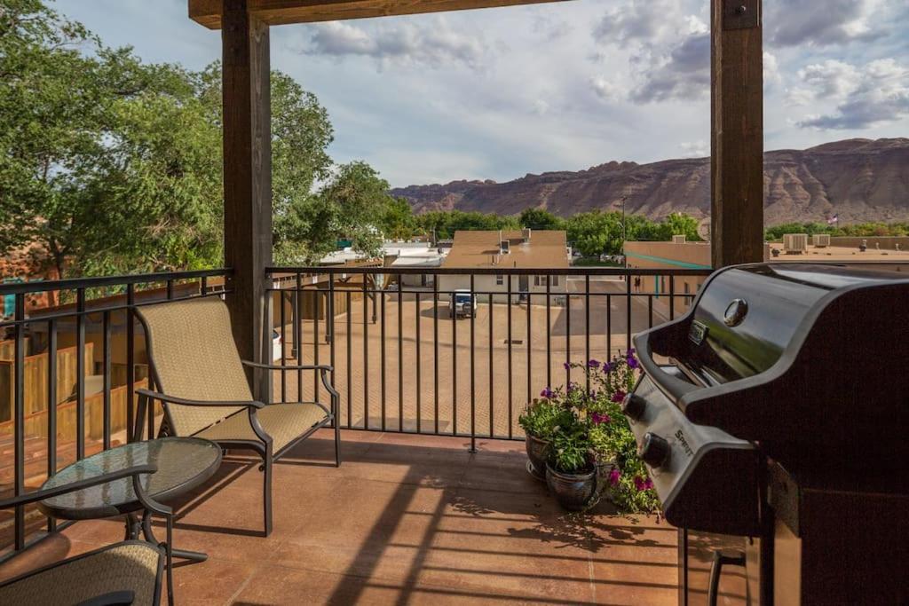 a porch with two chairs and a grill with mountains in the background at 57 Robber's Roost in Moab