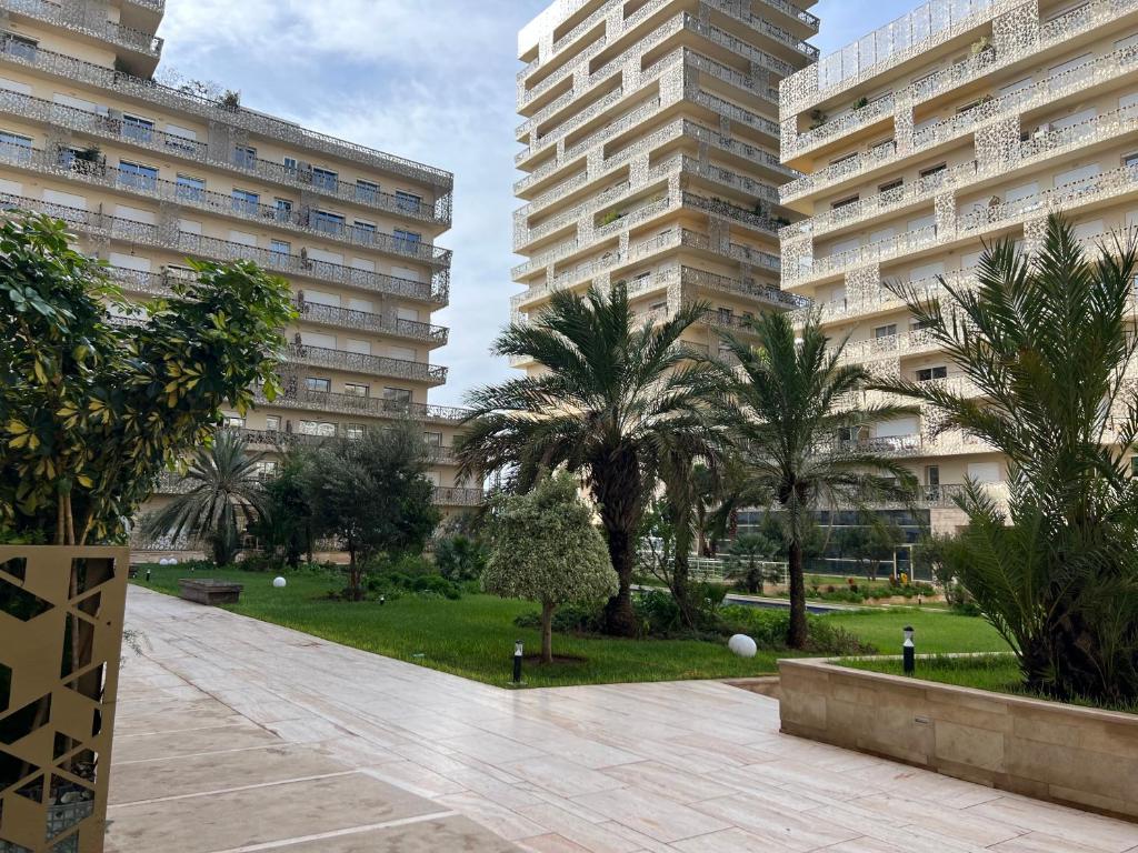 two tall buildings with palm trees in a park at Luxury Apart 2 CH -CASA FINANCE CITY in Casablanca