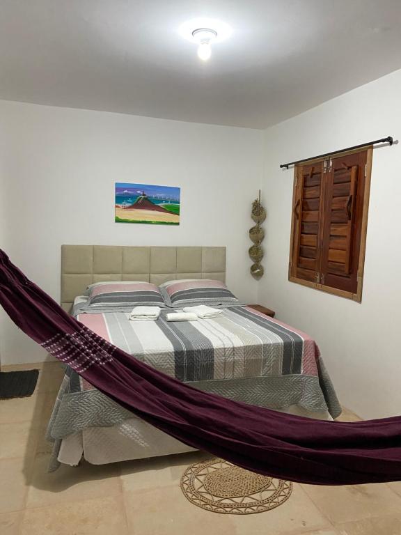 Bett mit Hängematte in einem Zimmer in der Unterkunft Jangadas do Pontal in Fortim