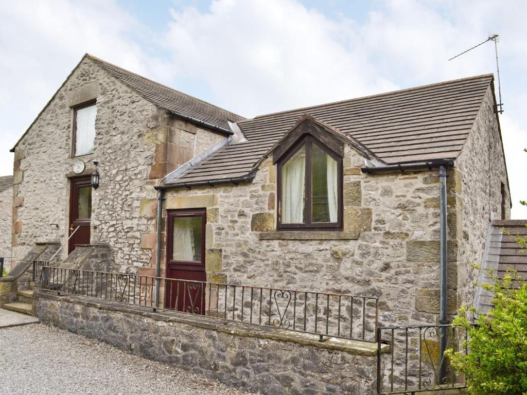 a stone house with a black roof at Harebell Hill Jericho Farm in Earl Sterndale