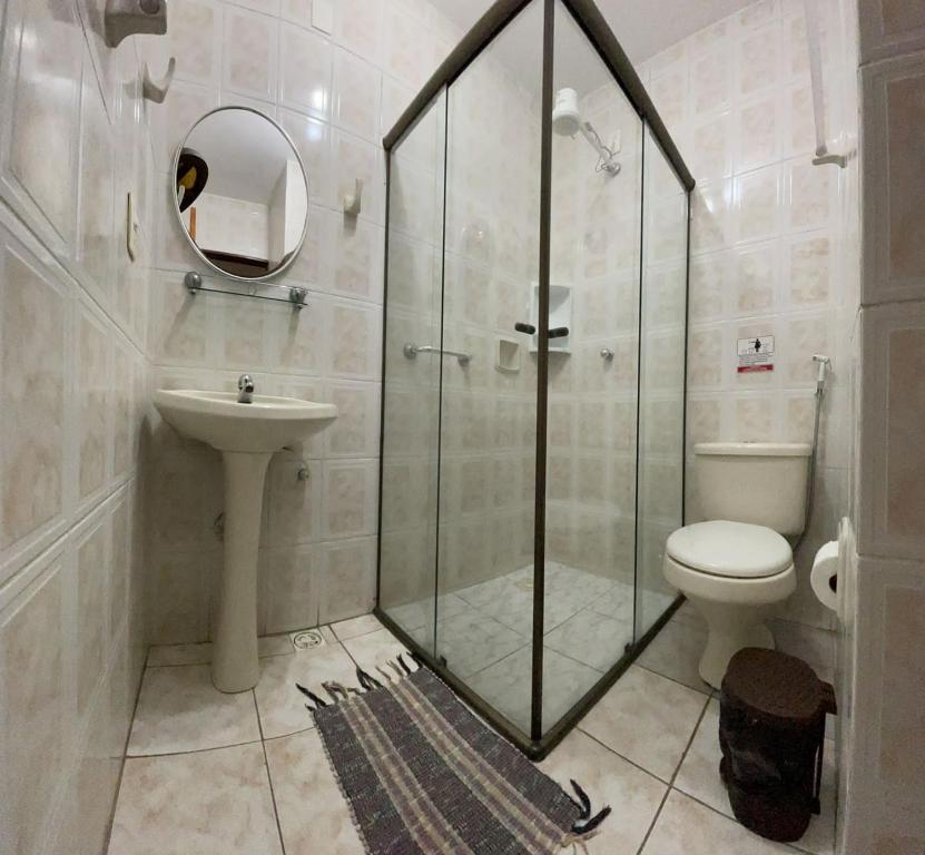 a bathroom with a shower and a toilet and a sink at Pousada Alecrim Dourado in Paraty