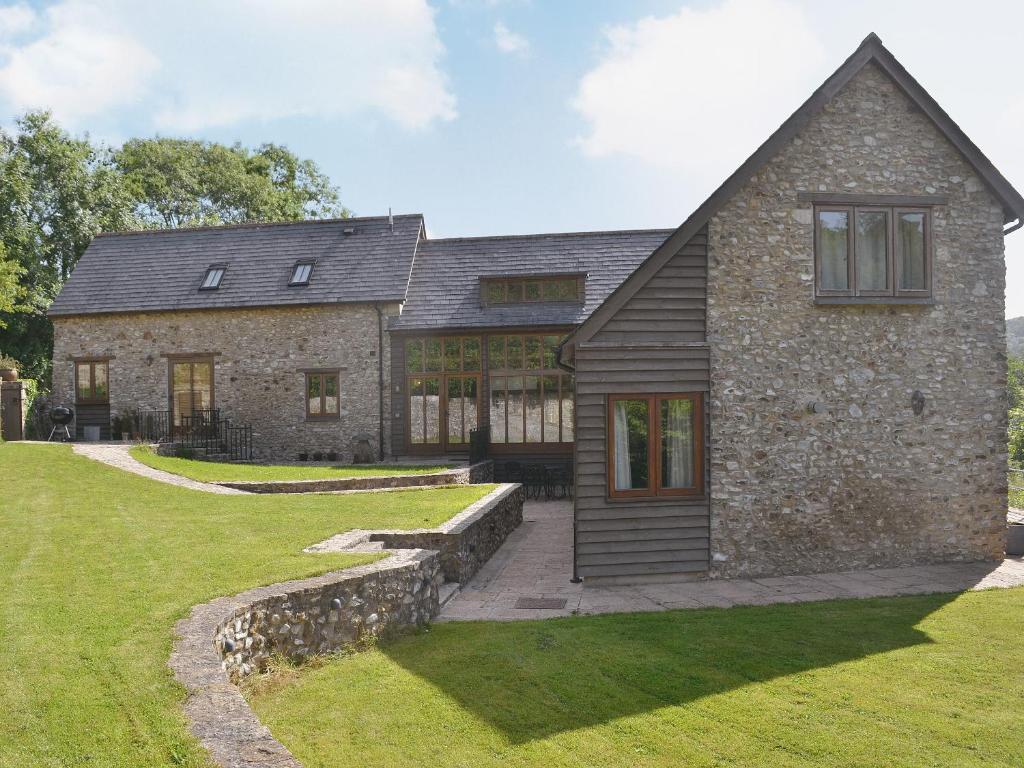 a stone house with a slate roof at Stockham Lodge in Colyton