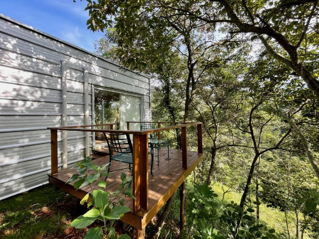 a deck with a table and chairs on a house at Baubrasil Village in Tiradentes