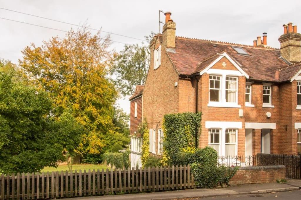 a brick house with a fence in front of it at Midsomer Cottage- Spacious Victorian Cottage with parking & garden - Close to City and ring road in Oxford