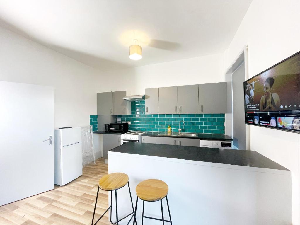 a kitchen with two stools and a counter top at Margate 2 Bed, Prime Location in Kent