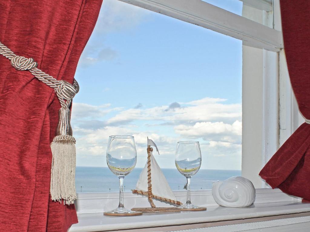 a window with two wine glasses and a lighthouse at Dawns Gem in Whitby