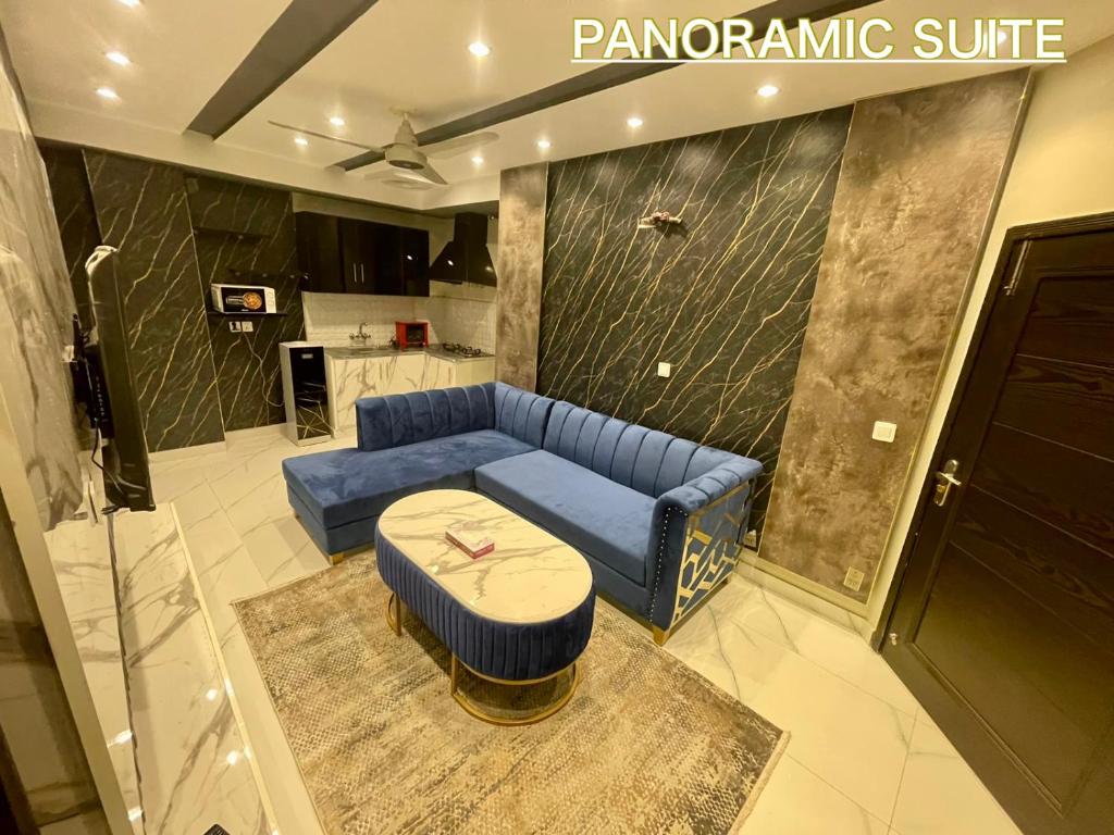 Burj Al Islam Bahria Suites في لاهور: غرفة معيشة مع أريكة زرقاء وطاولة