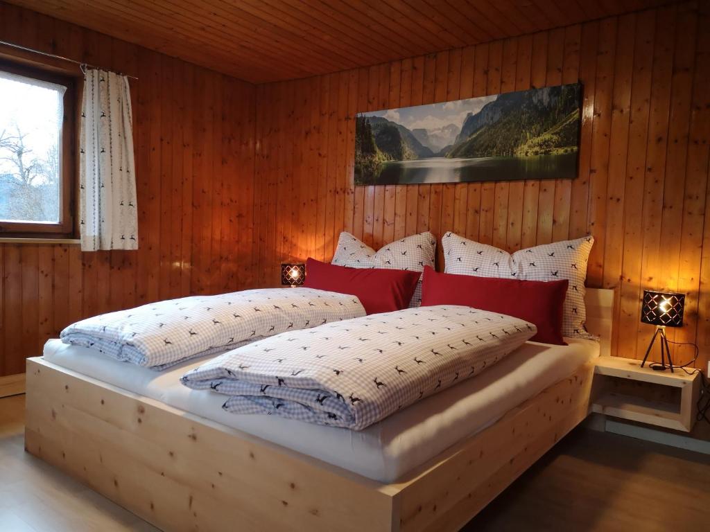 een slaapkamer met een groot bed met rode en witte kussens bij Erwin's in Bildstein