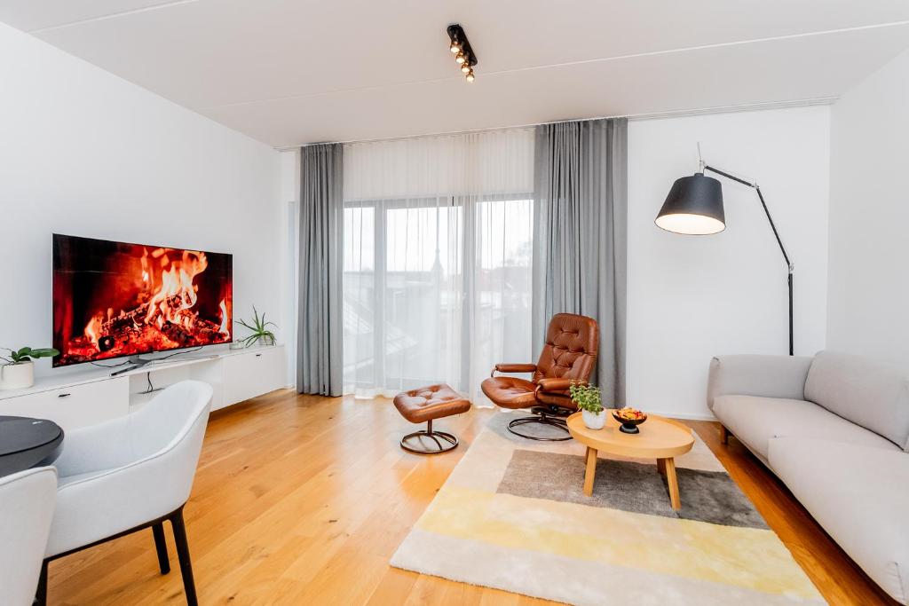 ein Wohnzimmer mit einer weißen Couch und einem Kamin in der Unterkunft Spacious apartment with terrace and grarage in Pärnu