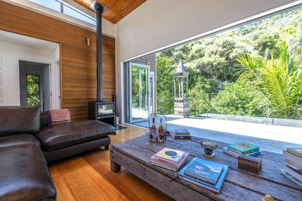 a living room with a couch and a table at Inside Out House in Oneroa