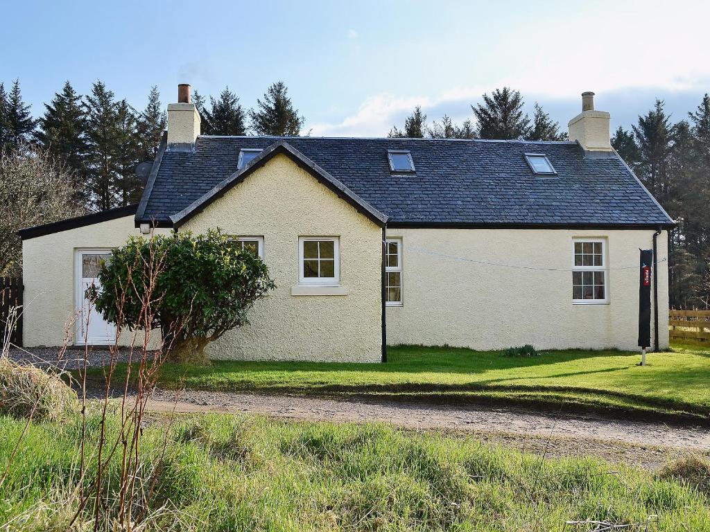 a white house with a black roof at Achavalich Cottage- 28330 in Clachan