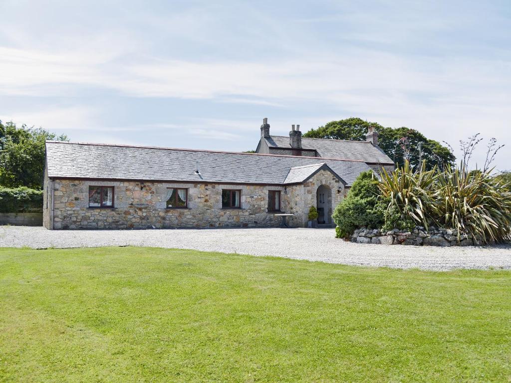 an old stone house with a grass yard at The Paddock in Saint Hilary