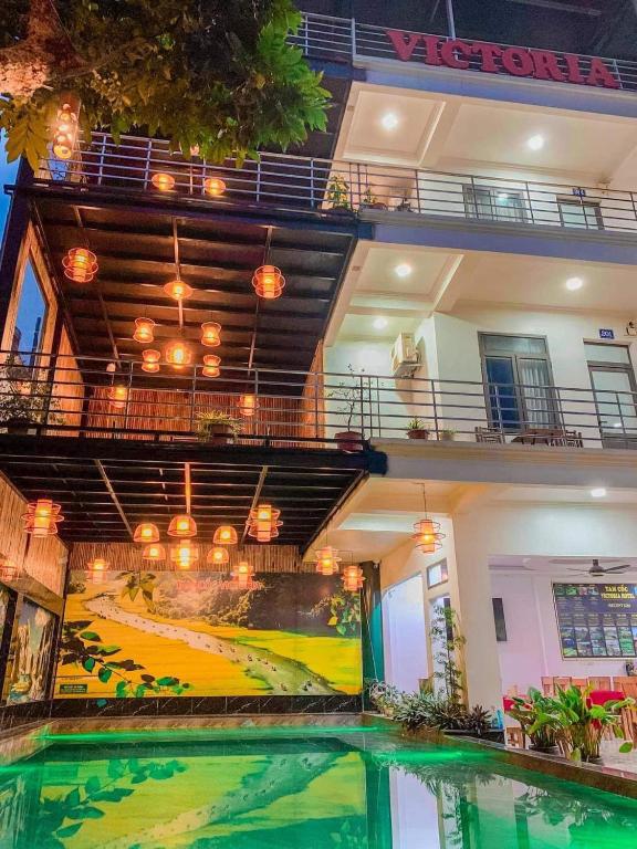 a swimming pool in front of a building with a painting at Tam Coc Victoria Hotel in Ninh Binh
