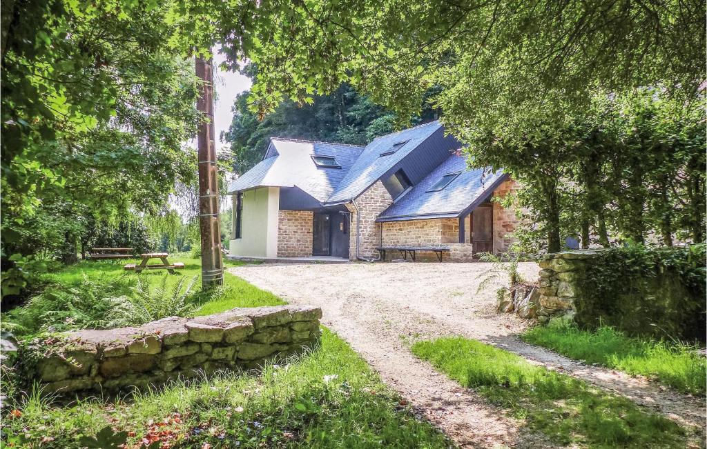 a stone house with a blue roof and a dirt road at 3 Bedroom Amazing Home In Bannalec in Bannalec