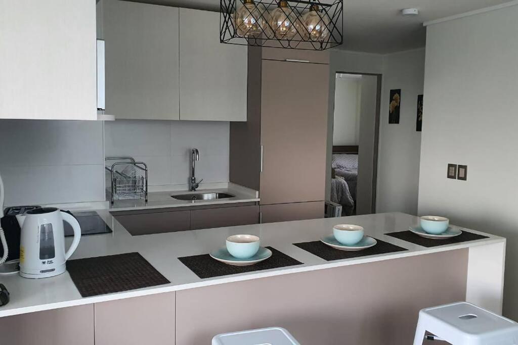 a kitchen with two cups and plates on a counter at Papudo, Chile in Papudo