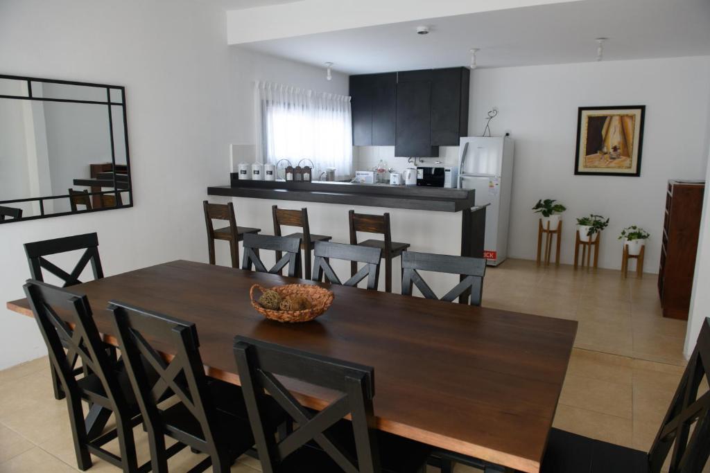 cocina y comedor con mesa de madera y sillas en Departamento con terraza y quincho con asador en Salta