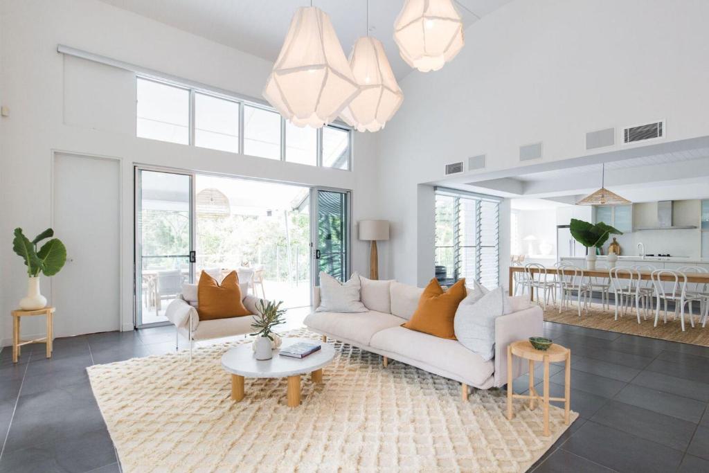 ヌーサヘッズにあるMamilla Beach House Designer Beach Houseの白いソファとテーブルのあるリビングルーム