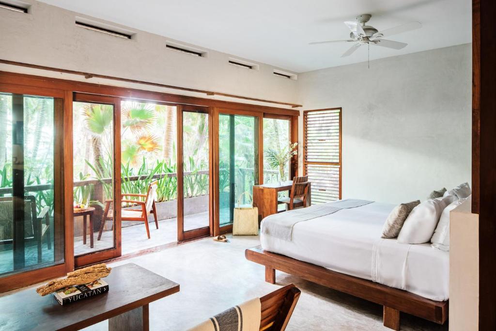 a bedroom with a bed and a table at Olas Tulum in Tulum