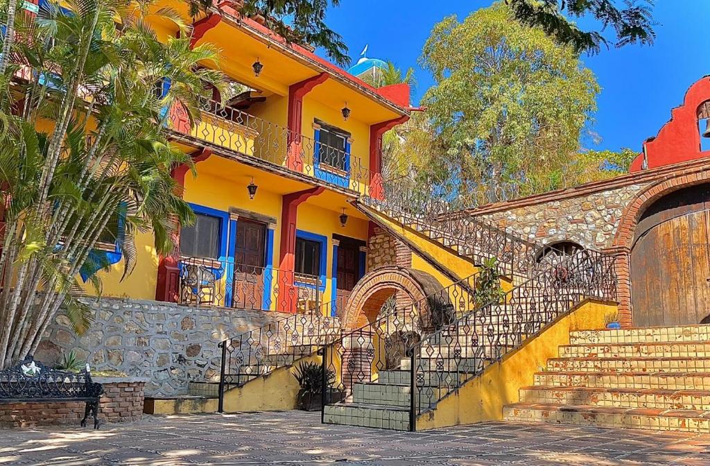 a yellow building with stairs in front of it at Hotel Rancho Escondito in Puerto Escondido