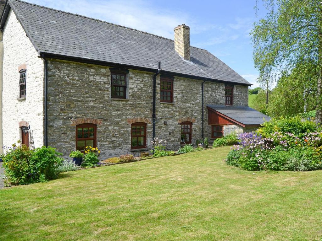 een oud stenen huis met een grote tuin bij The Oak in Newchurch