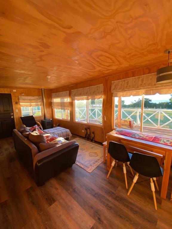 a living room with a couch and a piano at Cabaña en La Poza in Hualaihué