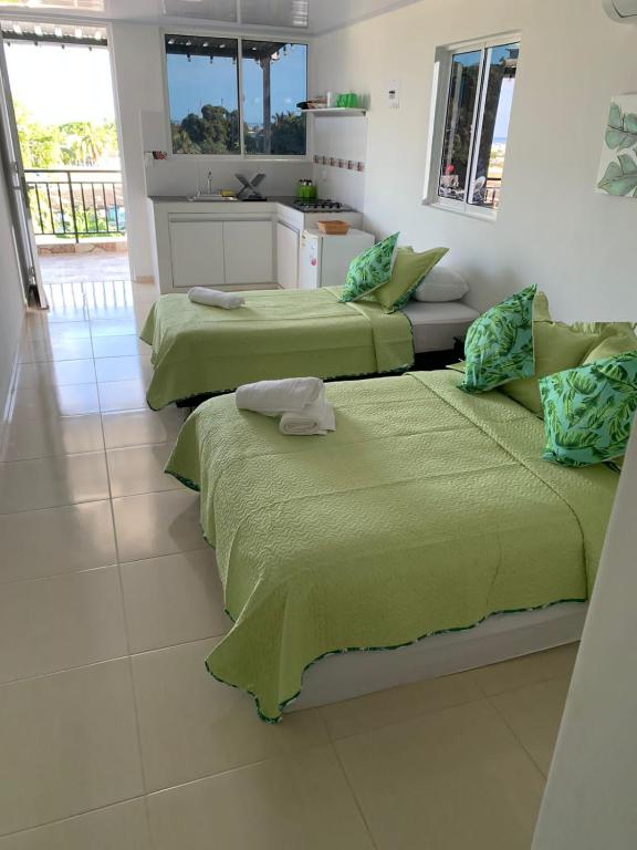 two green beds in a room with a kitchen at Aloha Beach SAI in San Andrés